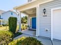 Inviting front porch with blue door, manicured shrubs, and well-maintained landscaping at 1004 Bridlemine Dr, Fuquay Varina, NC 27526