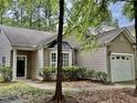 Exterior of a home with attached garage, mature trees and landscaping at 1017 Red Hat Ln, Durham, NC 27713