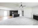 Spacious living room with a ceiling fan, fireplace, and an open view of the kitchen at 103 Hampshire Pl, Kenly, NC 27542