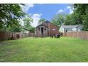 Expansive backyard featuring lush green grass, mature trees, and a brick patio area at 106 E Club Blvd, Durham, NC 27704