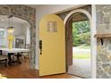 Bright foyer with a unique yellow door leading into a dining area with hardwood floors at 106 E Club Blvd, Durham, NC 27704