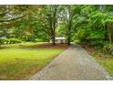 Scenic view of home nestled among trees, featuring a long gravel driveway at 1085 Bynum Rd, Pittsboro, NC 27312