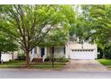 Inviting two-story home featuring a welcoming front porch and attached two-car garage, framed by mature trees at 116 Hamilton Hedge Pl, Cary, NC 27519