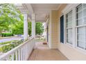 Covered front porch provides a charming view of the neighborhood street, with a window and blue shutter at 116 Hamilton Hedge Pl, Cary, NC 27519