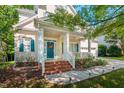 Inviting front porch with white columns, brick stairs, and a beautiful wreath on the blue front door at 116 Hamilton Hedge Pl, Cary, NC 27519