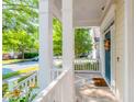 View of the front porch featuring white columns and railings, a blue front door, and neighborhood street views at 116 Hamilton Hedge Pl, Cary, NC 27519