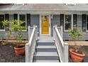 Entrance to house featuring a yellow front door with potted plants on either side of staircase at 1205 Elysian Way, Rougemont, NC 27572