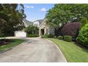 Brick home with well-maintained landscaping and a wide driveway leading to a side entry garage; offers great curb appeal at 1210 Brooks Ave, Raleigh, NC 27607