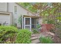 Charming screened-in back porch with peaceful setting surrounded by lush landscaping and greenery at 124 Twin Oaks Pl, Cary, NC 27511