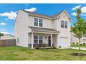 Two-story home featuring a welcoming front porch and well-maintained lawn in a suburban neighborhood at 13 Toplanders Ter, Gibsonville, NC 27249