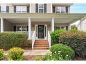 Inviting front porch with brick steps, white railings, and decorative plants framing the entrance at 1428 White Opal Dr, Knightdale, NC 27545