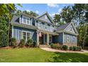 Charming two-story home with blue siding, stone accents, landscaped yard and American flag at 147 Gentry Dr, Pittsboro, NC 27312