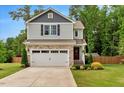 Well-maintained two-story house featuring a stone facade, two-car garage, and manicured lawn at 150 Teal Dr, Youngsville, NC 27596