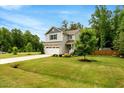 Lovely home surrounded by lush greenery and a well-maintained lawn with mature trees at 150 Teal Dr, Youngsville, NC 27596