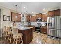 Spacious kitchen featuring an island with seating, granite countertops, stainless steel appliances, and hardwood floors at 187 Farrah-Shea Way, Angier, NC 27501