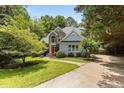 Well-maintained home with manicured landscaping, blue siding, and brick accents surrounded by mature trees at 215 Collinson Dr, Chapel Hill, NC 27514