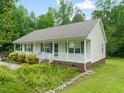 This charming home features a quaint front porch, brick foundation, and lovely landscaping at 215 Virginia Pine Dr, Clayton, NC 27520