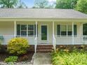Inviting front porch with white railings, a storm door, and decorative shutters at 215 Virginia Pine Dr, Clayton, NC 27520