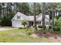 Attractive home surrounded by mature trees and manicured landscaping, providing privacy and curb appeal at 25 Spicetree Ct, Youngsville, NC 27596