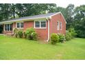 Charming brick ranch-style home featuring a well-maintained lawn and mature trees, offering a serene setting at 2626 Crestline Ave, Raleigh, NC 27603