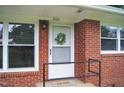 Inviting close-up of the front door featuring a decorative wreath and black handrails at 2626 Crestline Ave, Raleigh, NC 27603