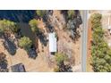 Aerial view showcases a house nestled beside a tranquil pond, complemented by a road running alongside the property at 2630 Ponderosa Rd, Cameron, NC 28326