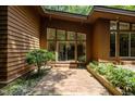 The house has a brick patio and surrounding landscaping that complements the wood exterior at 2706 Montgomery St, Durham, NC 27705