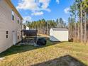 Backyard with a small shed, a pergola over a stone patio, and a partial view of the back of the house at 274 E Boulder Road Rd, Henderson, NC 27537