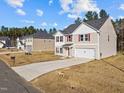 Two-story house with red shutters, vinyl siding, and a two-car garage is located in a residential neighborhood at 274 E Boulder Road Rd, Henderson, NC 27537