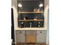 Charming bar area features sleek subway tiles, wooden shelves, and a beverage refrigerator for entertaining at 300 Bordeaux Ln, Cary, NC 27511