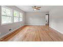 A well-lit and spacious living room featuring hardwood flooring and a ceiling fan at 3325 Old Buffaloe Rd, Raleigh, NC 27604