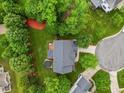 Aerial view of the home with lush greenery, mature trees, a deck, and a jacuzzi nestled in the backyard at 4 Pickard Pl, Durham, NC 27703