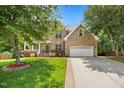 Charming brick home featuring a two-car garage, well-kept lawn, and inviting covered porch at 4 Pickard Pl, Durham, NC 27703