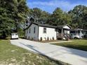Charming renovated home with a concrete driveway, landscaped yard, and a welcoming front porch at 401 Commonwealth St, Durham, NC 27703