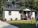 Charming renovated home with a concrete driveway, landscaped yard, and a welcoming front porch at 401 Commonwealth St, Durham, NC 27703
