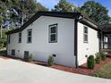 Charming side view of a renovated home with a concrete driveway and landscaped yard at 401 Commonwealth St, Durham, NC 27703