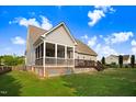 Backyard view featuring screened porch, wood deck, and green lawn at 479 Manchester Trail, Clayton, NC 27527