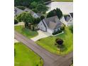 Charming two-story home featuring a manicured lawn, driveway, and attached garage, near a lake at 479 Manchester Trail, Clayton, NC 27527