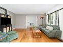 Bright living room featuring hardwood floors, neutral walls, and green furniture at 4808 Berini Dr, Durham, NC 27705