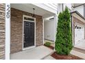 Close-up of front door with stone facade, black door, manicured landscaping and walkway at 520 Kenton Mill Ct, Rolesville, NC 27571