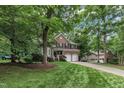 Beautiful home with a long driveway and lush green lawn surrounded by mature trees at 522 N Scotswood Blvd, Hillsborough, NC 27278