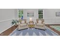 Cozy sitting room with neutral colors, two chairs, and natural light at 522 N Scotswood Blvd, Hillsborough, NC 27278