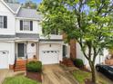 Attractive townhouse with a white exterior, black shutters, and a well-manicured front yard at 5506 Cottonrose Ln, Raleigh, NC 27606