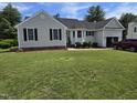 Inviting single-story home featuring a manicured lawn and gray siding, creating a classic look at 5810 Stardust Ct, Durham, NC 27712
