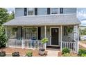 Inviting front porch with hanging ferns, white lattice, and comfortable seating area at 601 Country Ln, Holly Springs, NC 27540