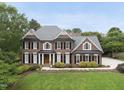 Well-maintained brick home with a lush green lawn, manicured bushes and a charming walkway to the front door at 704 Walcott Way, Cary, NC 27519