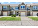 Beautiful townhomes showcasing stone accents, one-car garages, and charming front entrances with manicured lawns at 7807 Elmshire Way, Raleigh, NC 27616