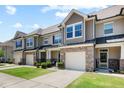 Charming townhomes with stone accents, one-car garages, inviting front entrances, and well-maintained lawns at 7807 Elmshire Way, Raleigh, NC 27616