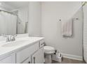 Bright bathroom featuring white vanity, white toilet, gray floor tiles, and light gray walls, with a towel rack at 805 Winter Meadow Dr, Wake Forest, NC 27587