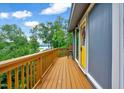 Outdoor deck with scenic views of lake and trees, featuring a railing, yellow door, and chair for relaxing outdoors at 819 & 818 Hilltop Cir, Sanford, NC 27332